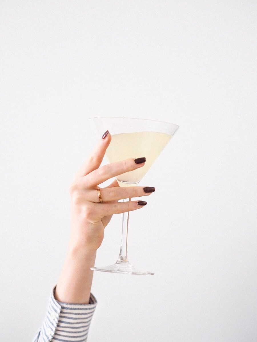 person holding clear martini glass